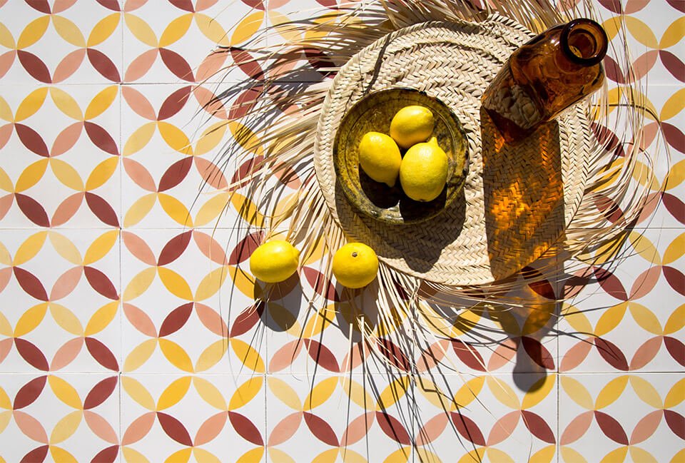 Lemon and straw hat on colored cement tiles designed by Glazentile