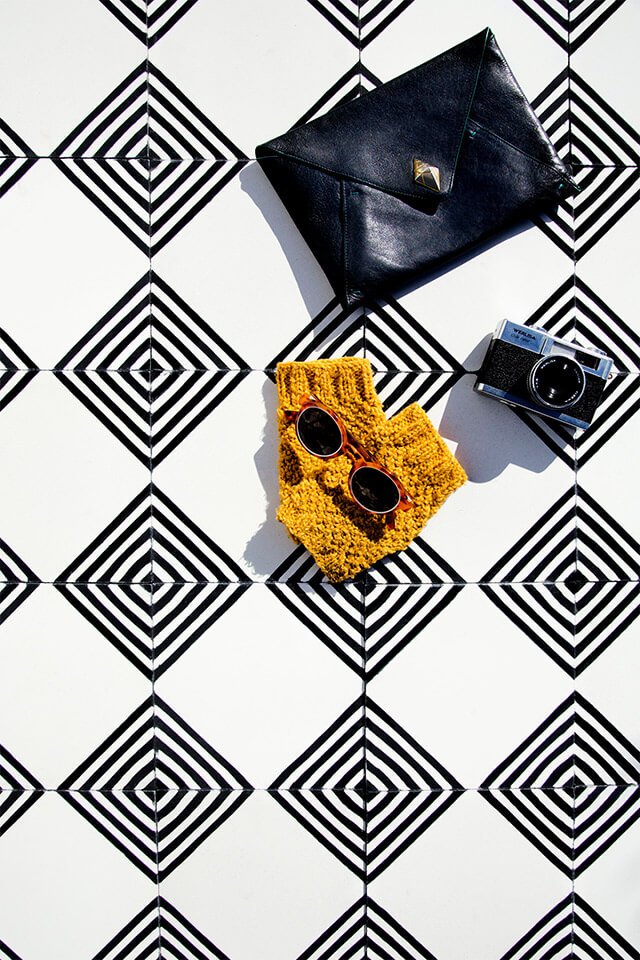 Thick yarn yellow gloves and a New Tangier bag on black and white cement tile from Glazentile