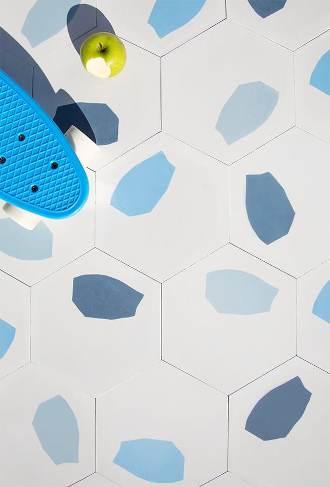 Blue skateboard and a green apple on a terrazzo style cement tile designed by Glazentile
