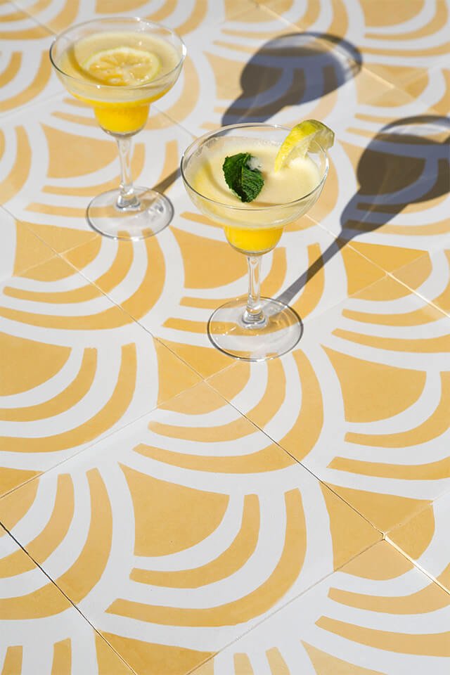 Morning mimosa and lemon cocktails on a bright yellow cement tile designed by Glazentile